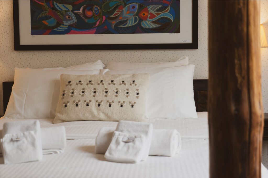 Double bed with natural textiles in Mia Glamping hotel room in Saaremaa